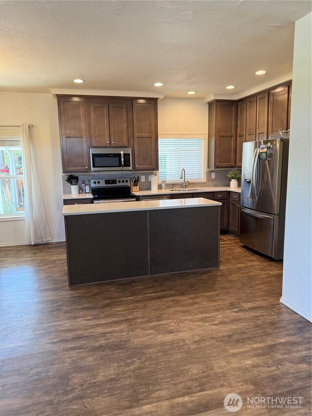 2101 S 324th St Unit 107, Federal Way, WA 98003 - kitchen featuring stainless steel appliances, a sink, light countertops, dark wood-style floors, and recessed lighting