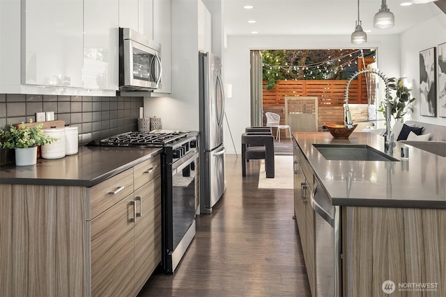 252 E Roanoke St, Seattle, WA 98102 - kitchen featuring appliances with stainless steel finishes, modern cabinets, dark wood finished floors, tasteful backsplash, and dark countertops