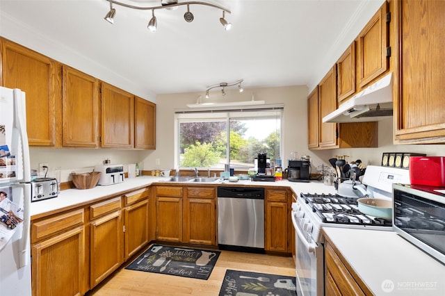 9757 Spinnaker Blvd NW, Silverdale, WA 98383 - kitchen with appliances with stainless steel finishes, under cabinet range hood, light countertops, and light wood-style floors