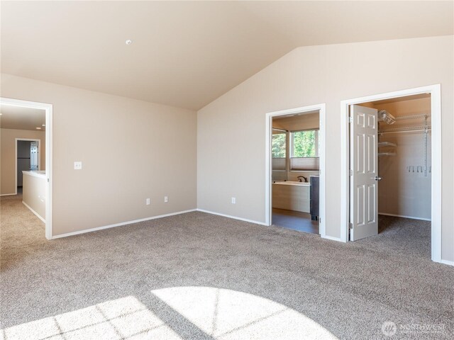 2422 Highland View Dr, East Wenatchee, WA 98802 - unfurnished bedroom featuring a walk in closet, carpet flooring, vaulted ceiling, baseboards, and ensuite bathroom