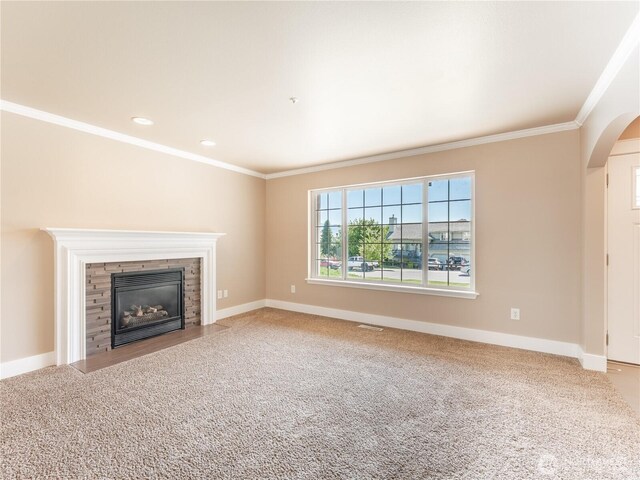 2422 Highland View Dr, East Wenatchee, WA 98802 - unfurnished living room featuring crown molding, arched walkways, a fireplace with flush hearth, carpet, and baseboards
