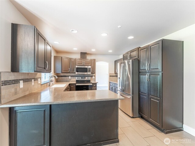 2422 Highland View Dr, East Wenatchee, WA 98802 - kitchen with appliances with stainless steel finishes, a sink, tasteful backsplash, light countertops, and a peninsula