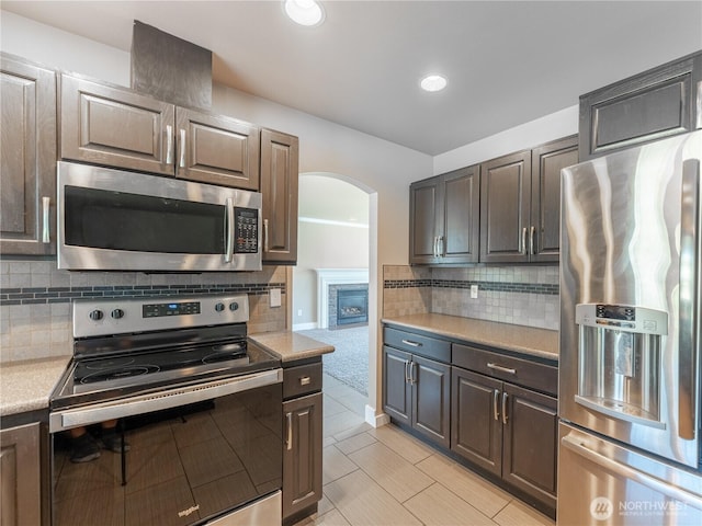 2422 Highland View Dr, East Wenatchee, WA 98802 - kitchen with appliances with stainless steel finishes, light countertops, arched walkways, decorative backsplash, and recessed lighting