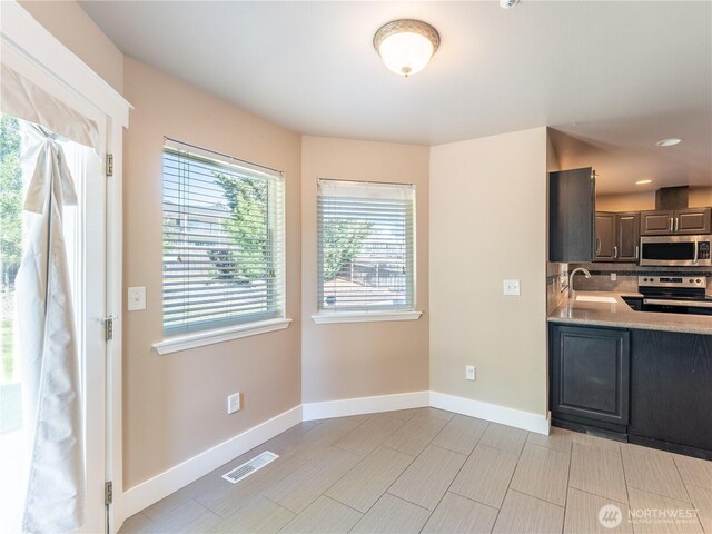 2422 Highland View Dr, East Wenatchee, WA 98802 - kitchen featuring stainless steel appliances, a sink, light countertops, baseboards, and decorative backsplash