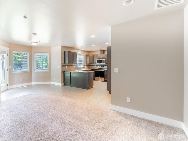 2422 Highland View Dr, East Wenatchee, WA 98802 - kitchen featuring appliances with stainless steel finishes, open floor plan, decorative backsplash, light carpet, and baseboards