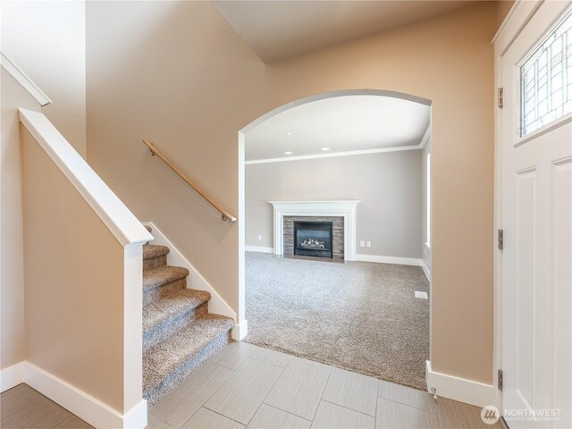 2422 Highland View Dr, East Wenatchee, WA 98802 - carpeted entrance foyer featuring arched walkways, a fireplace with flush hearth, crown molding, and baseboards
