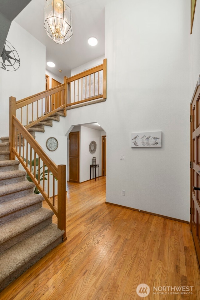 3905 109th Pl SE, Everett, WA 98208 - stairs with arched walkways, a high ceiling, wood finished floors, and a chandelier
