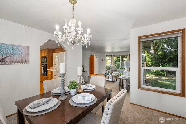 3905 109th Pl SE, Everett, WA 98208 - dining area featuring light colored carpet, arched walkways, and a chandelier