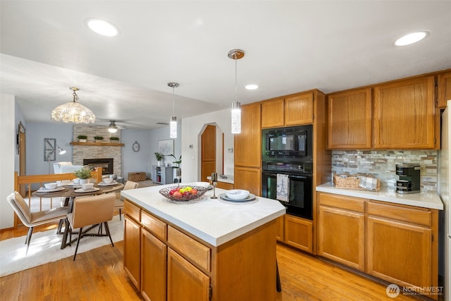 3905 109th Pl SE, Everett, WA 98208 - kitchen featuring black appliances, light countertops, a large fireplace, light wood-style floors, and recessed lighting