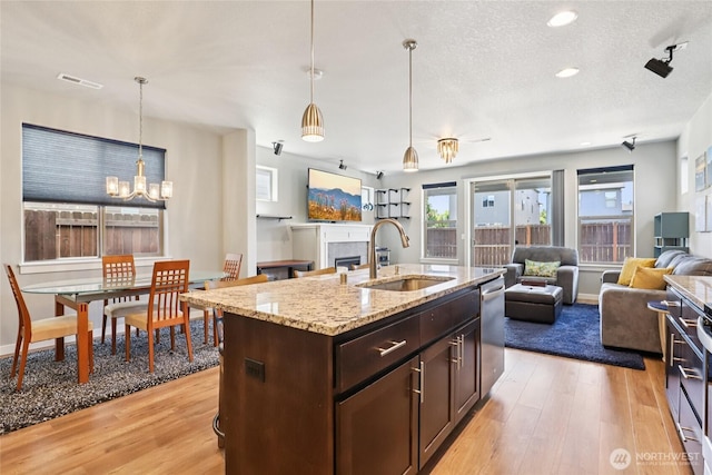 15323 NE 108th Way, Vancouver, WA 98682 - kitchen featuring open floor plan, light wood finished floors, dark brown cabinets, dishwasher, and a textured ceiling
