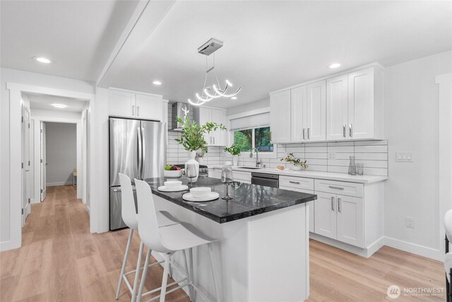 7713 NE 141st St, Kirkland, WA 98034 - kitchen featuring appliances with stainless steel finishes, light wood-type flooring, backsplash, white cabinets, and a breakfast bar area