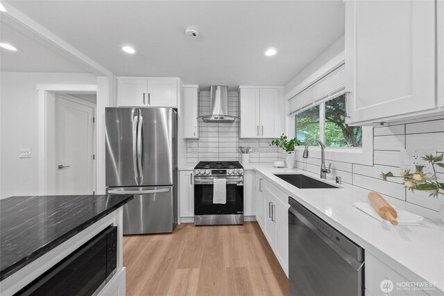 7713 NE 141st St, Kirkland, WA 98034 - kitchen with stainless steel appliances, wall chimney range hood, light wood finished floors, white cabinets, and decorative backsplash
