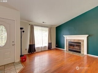 2518 NE 82nd Way, Vancouver, WA 98665 - unfurnished living room featuring wood finished floors, a tiled fireplace, and baseboards