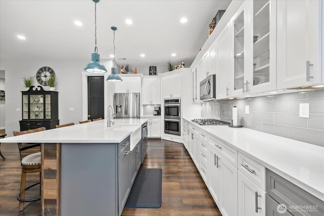18705 232nd Ave E, Orting, WA 98360 - kitchen featuring stainless steel appliances, light countertops, a kitchen bar, gray cabinetry, and white cabinetry