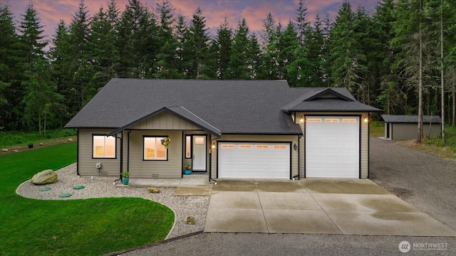 18705 232nd Ave E, Orting, WA 98360 - view of front of home with concrete driveway, a garage, a lawn, and a shingled roof