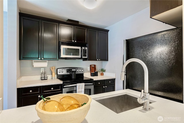 3446A 34th Ave W, Seattle, WA 98199 - kitchen featuring appliances with stainless steel finishes, dark cabinetry, and light countertops