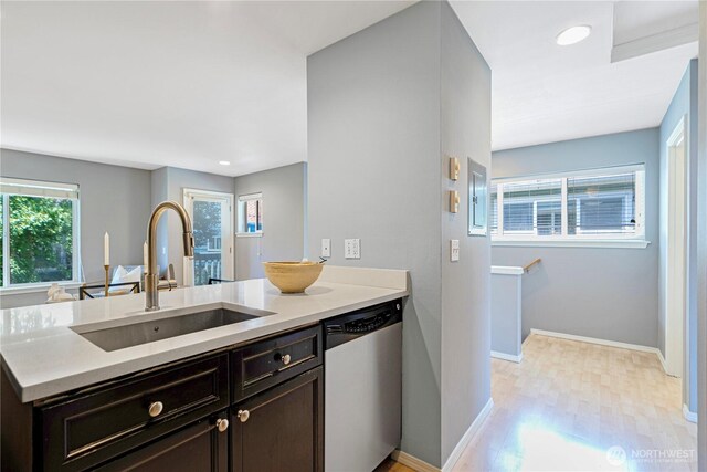 3446A 34th Ave W, Seattle, WA 98199 - kitchen with dishwasher, a peninsula, light countertops, light wood-style floors, and dark brown cabinets