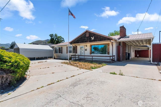 1300 Monitor Ave, Wenatchee, WA 98801 - ranch-style home with driveway, a chimney, an attached carport, and metal roof