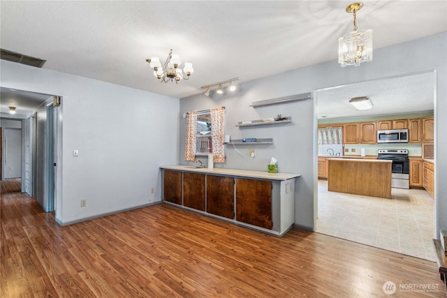 1300 Monitor Ave, Wenatchee, WA 98801 - kitchen featuring stainless steel appliances, a chandelier, and light wood-style floors