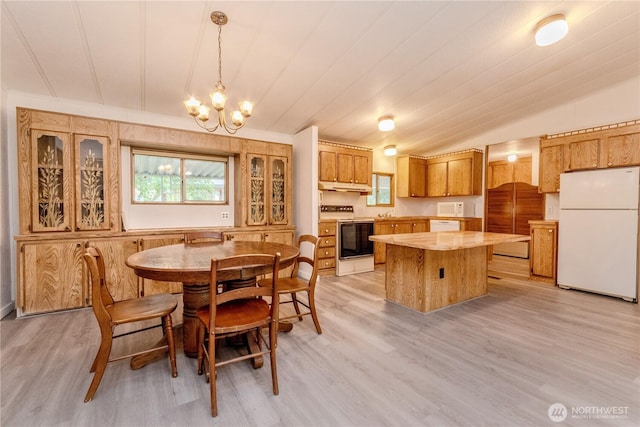 24443 Wicker Rd Unit 16, Sedro Woolley, WA 98284 - dining area with light wood-style flooring, a chandelier, and vaulted ceiling
