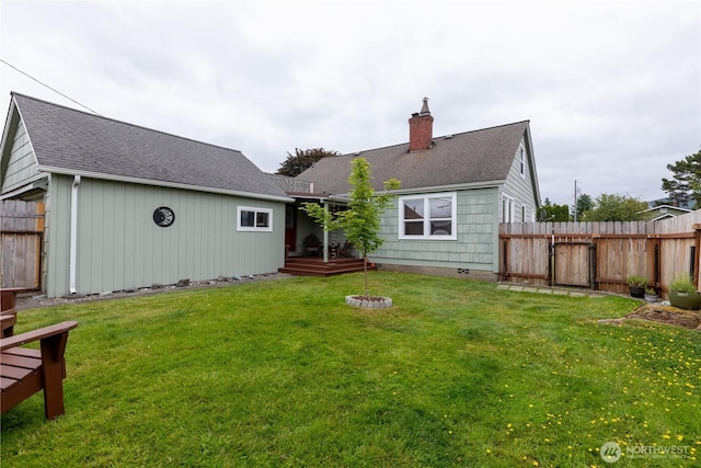 50 Blackberry St, Forks, WA 98331 - back of property featuring a chimney, a fenced backyard, a deck, and a shingled roof