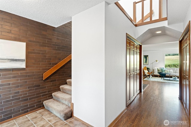 10742 Glen Acres Dr S Unit T-27, Seattle, WA 98168 - stairs featuring wood finished floors, brick wall, and a textured ceiling
