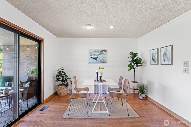 10742 Glen Acres Dr S Unit T-27, Seattle, WA 98168 - dining area with a textured ceiling, ornamental molding, wood finished floors, and brick wall