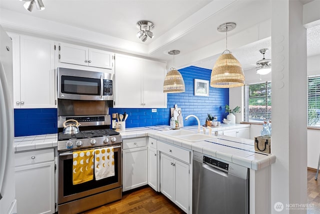 10742 Glen Acres Dr S Unit T-27, Seattle, WA 98168 - kitchen with appliances with stainless steel finishes, tile counters, a peninsula, and tasteful backsplash