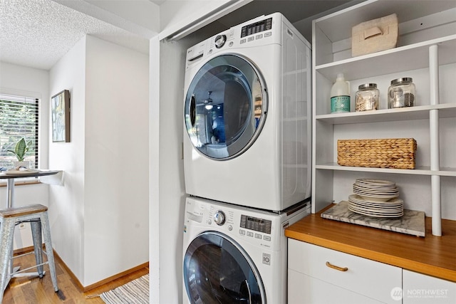 10742 Glen Acres Dr S Unit T-27, Seattle, WA 98168 - laundry area with stacked washer / dryer, light wood finished floors, a textured ceiling, and cabinet space