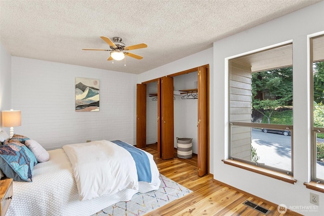10742 Glen Acres Dr S Unit T-27, Seattle, WA 98168 - bedroom featuring light wood-style floors, a textured ceiling, a ceiling fan, and a closet