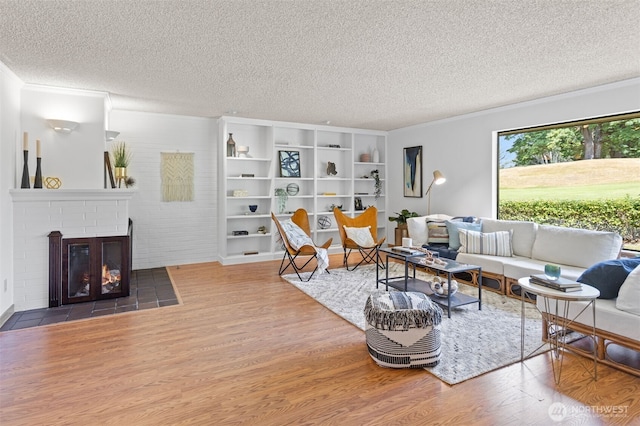 10742 Glen Acres Dr S Unit T-27, Seattle, WA 98168 - living room with a textured ceiling, wood finished floors, a fireplace, and ornamental molding