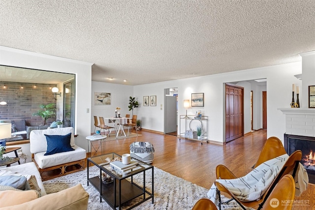 10742 Glen Acres Dr S Unit T-27, Seattle, WA 98168 - living area featuring wood finished floors, a textured ceiling, and a fireplace