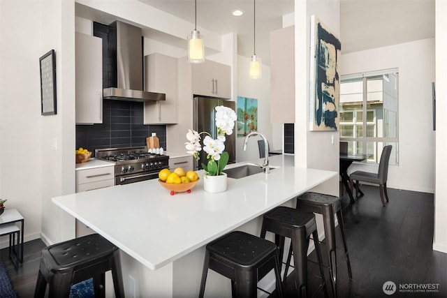 111 Martin Luther King Jr Way, Seattle, WA 98122 - kitchen featuring wall chimney exhaust hood, appliances with stainless steel finishes, a kitchen breakfast bar, backsplash, and dark wood-style flooring
