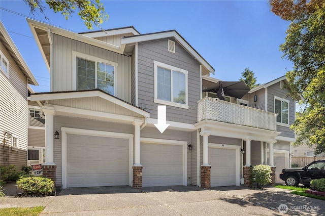 5100 Talbot Pl S Unit F, Renton, WA 98055 - view of front of property featuring a garage, a balcony, board and batten siding, brick siding, and driveway