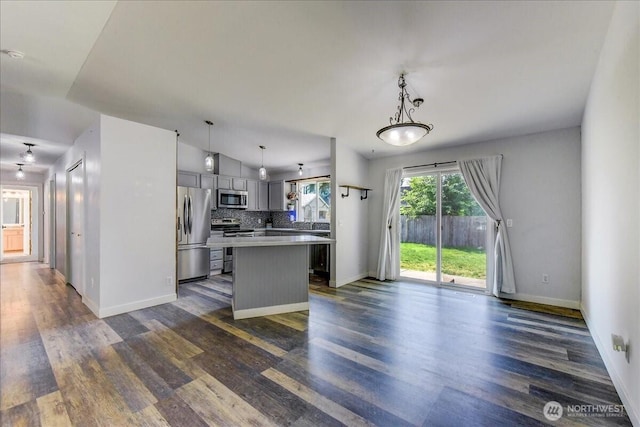7116 200th Street Ct E, Spanaway, WA 98387 - kitchen featuring appliances with stainless steel finishes, dark wood-type flooring, gray cabinets, a kitchen island, and light countertops