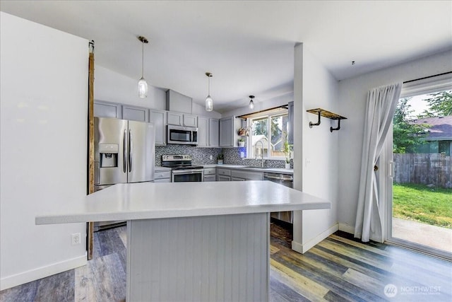 7116 200th Street Ct E, Spanaway, WA 98387 - kitchen with stainless steel appliances, gray cabinets, light countertops, decorative backsplash, and vaulted ceiling
