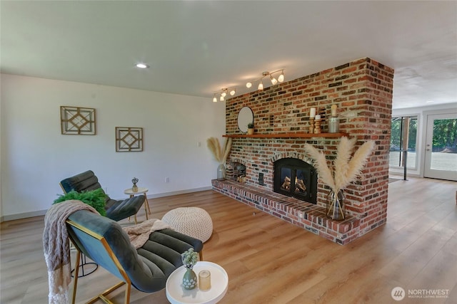 3327 170th Ave E, Lake Tapps, WA 98391 - living room with wood finished floors, baseboards, and a brick fireplace