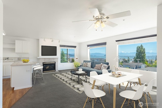 910 34th St Unit 302, Anacortes, WA 98221 - living room with a tiled fireplace, ceiling fan, and dark wood-style floors