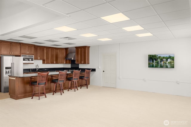 431 Airport Way SW, Mattawa, WA 99349 - kitchen featuring high quality fridge, a breakfast bar area, dark countertops, wall chimney exhaust hood, and a peninsula
