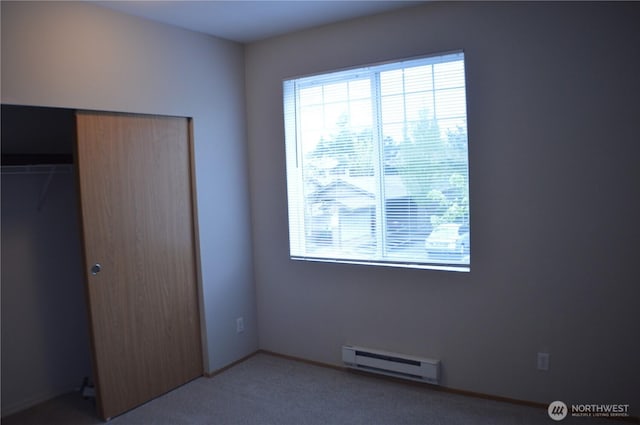 10825 SE 200th St Unit H201, Kent, WA 98031 - unfurnished bedroom featuring a baseboard radiator, light colored carpet, and a closet