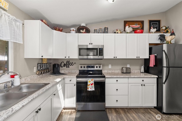 101 Shenandoah Dr, Silverlake, WA 98645 - kitchen featuring stainless steel appliances, wood finished floors, white cabinetry, and vaulted ceiling