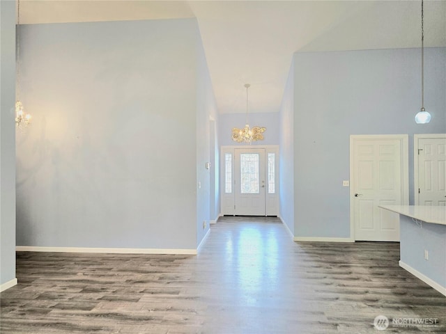 861 Willow Ct SW, Ocean Shores, WA 98569 - foyer with a chandelier, high vaulted ceiling, wood finished floors, and baseboards
