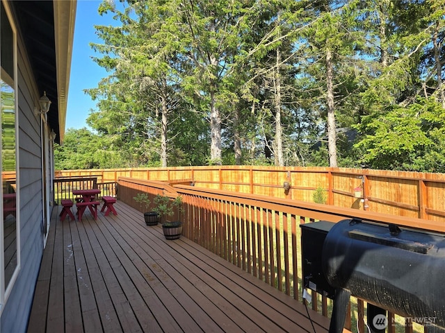 861 Willow Ct SW, Ocean Shores, WA 98569 - wooden deck with a fenced backyard, view of scattered trees, and outdoor dining area