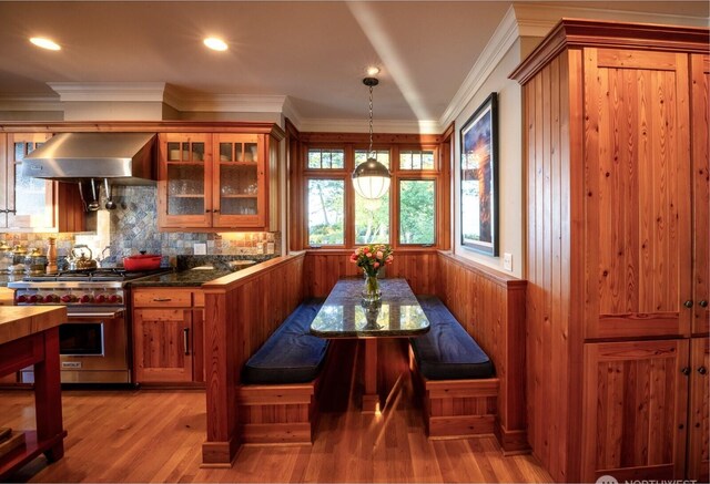 385 Sunset Ave, Orcas Island, WA 98245 - kitchen with wall chimney exhaust hood, designer range, brown cabinets, light wood-type flooring, and glass insert cabinets