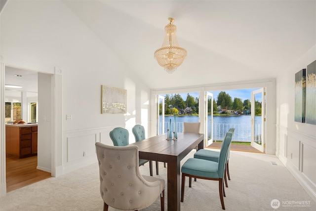 3604 Serene Way, Lynnwood, WA 98087 - dining space featuring light carpet, a chandelier, a water view, lofted ceiling, and a decorative wall