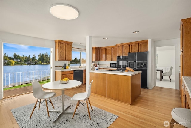 3604 Serene Way, Lynnwood, WA 98087 - kitchen with black appliances, light wood finished floors, brown cabinetry, light countertops, and a water view