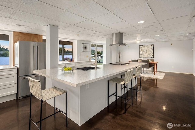 3604 Serene Way, Lynnwood, WA 98087 - kitchen with freestanding refrigerator, wall chimney range hood, a kitchen bar, light countertops, and a drop ceiling