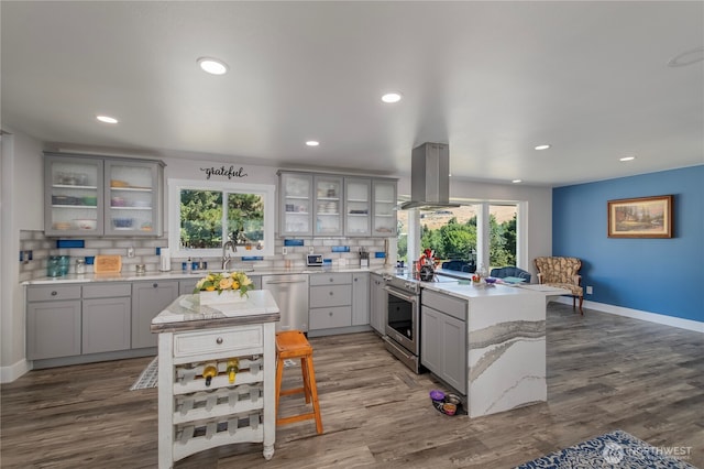3418 Mari Lane Dr, Wenatchee, WA 98801 - kitchen featuring appliances with stainless steel finishes, island exhaust hood, gray cabinetry, a peninsula, and plenty of natural light