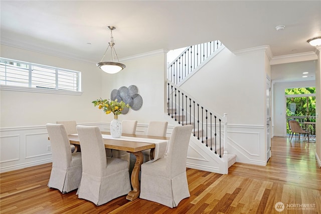 17445 NE 28th St, Redmond, WA 98052 - dining space featuring crown molding, healthy amount of natural light, a decorative wall, light wood-style floors, and stairway