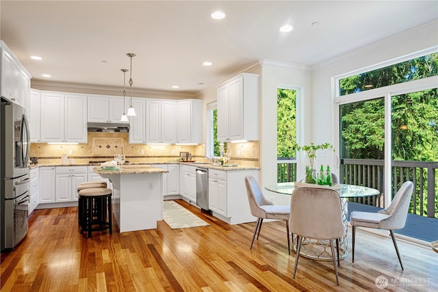 17445 NE 28th St, Redmond, WA 98052 - kitchen with stainless steel appliances, under cabinet range hood, light wood-style flooring, white cabinetry, and a kitchen island